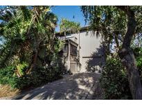 Two-story home with a large screened porch and a paved driveway, nestled among lush tropical landscaping at 1460 Landings Cir # 51, Sarasota, FL 34231