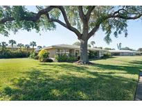 Tan single story house with a large oak tree in the front yard at 3289 Fairhaven Ln # 112, Sarasota, FL 34239