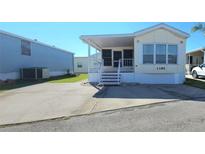Front view of a yellow single-wide manufactured home with a carport and landscaping at 3333 26Th E Ave # 1195, Bradenton, FL 34208