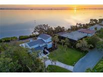 Waterfront property showcasing a home with a spacious yard and sunset views at 3804 Bayside Dr, Bradenton, FL 34210