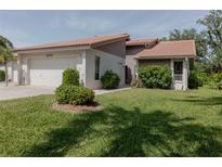 Charming single-story home with a lush green lawn and tile roof offers great curb appeal at 4002 Wilshire E Cir # 90, Sarasota, FL 34238