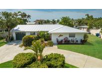 Single-story home with metal roof, landscaping, and driveway at 526 69Th St, Holmes Beach, FL 34217