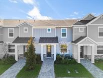 Modern 2 story townhome with gray exterior and a paved walkway at 7408 Cabin Ln, Sarasota, FL 34240