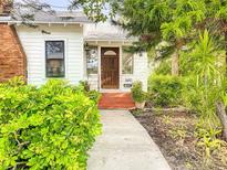 Charming white house with brick accents, lush landscaping, and a walkway to the front door at 1420 22Nd W St, Bradenton, FL 34205
