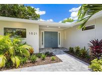 Modern home exterior with a blue front door and landscaped walkway at 1621 Pine Bay Dr, Sarasota, FL 34231