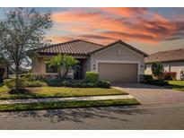 One-story home with tile roof, attached garage, and landscaped yard at 6517 Willowshire Way, Bradenton, FL 34212