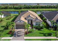 Single-Gathering home with a two-car garage, waterfront lot, and lush landscaping at 764 Tailwind Pl, Sarasota, FL 34240