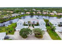 Two-story building near a lake with beautiful landscaping at 905 Addington Ct # 203, Venice, FL 34293