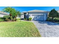 Single-story home with gray exterior, two-car garage, and landscaped lawn at 9750 53Rd E Dr, Bradenton, FL 34211
