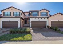 Three-story townhouses with brown garages and landscaped yards at 10817 Tarflower Dr # 202, Venice, FL 34293