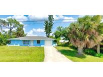 Cute light blue house with a one car garage and a large front yard at 11058 Deerwood Ave, Englewood, FL 34224