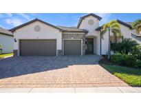 Two-car garage, paver driveway, and nicely landscaped front yard at 13299 Rinella St, Venice, FL 34293