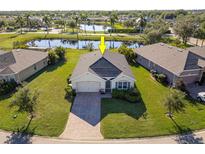 House situated in a community with a lake and other homes at 28214 Arrowhead Cir, Punta Gorda, FL 33982
