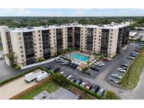 Aerial view of a large apartment building with a pool and ample parking at 2901 26Th W St # 601, Bradenton, FL 34205