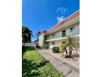 Exterior view of a condo building with well-maintained landscaping and walkway at 3504 Beneva Rd # 206, Sarasota, FL 34239