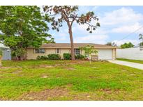 Single-story home with a spacious lawn and attached garage at 801 Church St, Nokomis, FL 34275