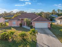 Attractive single-story home with a two-car garage and lush landscaping at 2421 Palomar St, North Port, FL 34287