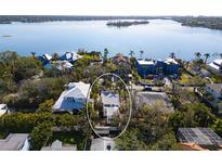 An aerial shot showcasing a house near the water, surrounded by other homes and greenery at 4189 Roberts Point Cir, Sarasota, FL 34242