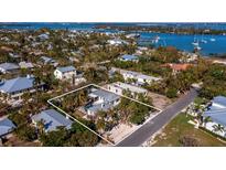 Aerial view of a single-Gathering home with a large backyard and surrounding neighborhood at 611 Hibiscus Way, Longboat Key, FL 34228