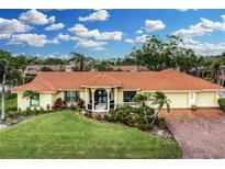 Single-story home with tile roof, landscaping, and a brick driveway at 312 Yacht Harbor Dr, Osprey, FL 34229