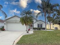 Single-story home with white exterior, two-car garage, and palm trees at 4514 Sanibel Way, Bradenton, FL 34203