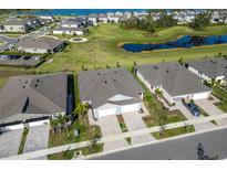 Aerial view of a community with houses, lakes, and landscaping at 5967 Timberdale Ave, Wesley Chapel, FL 33545