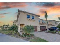 Exterior of a beautiful two-story townhome with a two-car garage and landscaped yard at 7835 Hidden Creek Loop # 101, Lakewood Ranch, FL 34202