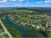 Aerial view of house on golf course with lake access at 8843 Wild Dunes Dr, Sarasota, FL 34241