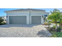 Two-car garage with herringbone driveway and landscaping at 10300 Lake George Ave, Sarasota, FL 34241