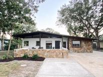 Mid-century modern home with stone accents and a covered patio at 2820 Novus St, Sarasota, FL 34237