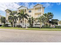 Three-story building with light-colored exterior, palm trees, and landscaping at 7830 34Th W Ave # 102, Bradenton, FL 34209