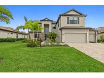 Beautiful two-story home featuring a well-manicured lawn and a two-car garage at 17335 Polo Trl, Bradenton, FL 34211