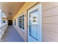 Condo entrance featuring a well-lit exterior hallway, door with glass, and an adjacent window at 2435 Sumatran Way # 35, Clearwater, FL 33763