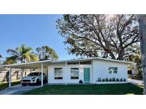 White mid-century modern home with carport and landscaped lawn at 2946 Bay St, Sarasota, FL 34237