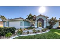 Light blue house with a two-car garage and landscaped yard at 42 Marker Rd, Rotonda West, FL 33947