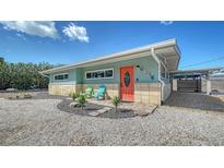 Charming beach house featuring colorful accents, well-kept landscaping, and a covered carport at 4626 Gleason Ave, Sarasota, FL 34242