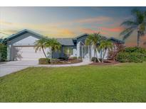 One-story home with landscaped lawn and palm trees at 527 Rotonda Cir, Rotonda West, FL 33947