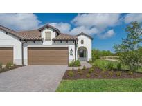 Two-car garage with paver driveway and nicely landscaped front yard at 26903 Pavin Dr, Englewood, FL 34223