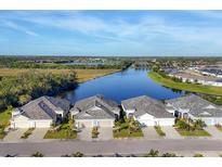 Stunning aerial view of homes nestled along a tranquil waterfront, showcasing the community's serene setting and beautiful landscaping at 3115 Trustee Ave, Sarasota, FL 34243
