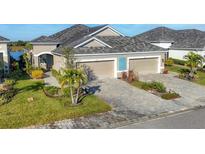 Beautiful home featuring a two-car garage, paver driveway, tropical landscaping, and neutral color palette at 3115 Trustee Ave, Sarasota, FL 34243