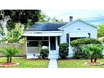 Charming white house with a porch, well-manicured lawn, and mature trees at 3642 Dartmouth N Ave, St Petersburg, FL 33713