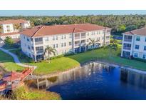 Beautiful condominium complex featuring a lake with a gazebo, lush landscaping and well-maintained exterior at 500 San Lino Cir # 511, Venice, FL 34292