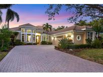 Elegant two-story home with a paver driveway and landscaped yard at 7041 Beechmont Ter, Lakewood Ranch, FL 34202