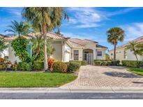 Attractive single-story home with tile roof, lush landscaping, and paver driveway at 7156 Rue De Palisades # 3, Sarasota, FL 34238