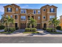 Tan three-story townhouses with palm trees and lush landscaping at 8954 White Sage, Lakewood Ranch, FL 34202