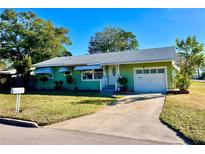 Ranch style home with a green exterior, attached garage, and well-manicured lawn at 2113 20Th W St, Bradenton, FL 34205