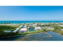 Aerial view of condo community near the ocean, showing buildings and landscaping at 3705 E Bay Dr # 212, Holmes Beach, FL 34217
