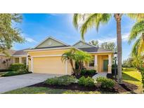 One-story house with yellow walls, green door, and a two-car garage at 5032 Newport News Cir, Bradenton, FL 34211