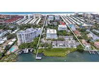 Aerial view of waterfront property, showing building, pool, tennis courts, and beach access at 1200 E Peppertree Ln # 607, Sarasota, FL 34242