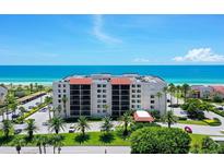 Coastal condo building with ocean views, lush landscaping, and ample parking at 2045 Gulf Of Mexico Dr # M1-502, Longboat Key, FL 34228